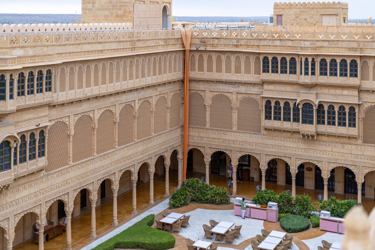 Explore the intricate sandstone architecture of a Jaisalmer heritage hotel courtyard.